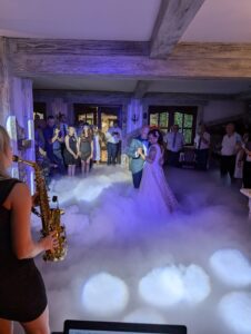 Para młoda tańcząca pierwszy taniec, w tle klimatyczne oświetlenie koncertowe zapewnione przez dj na wesele Śląsk.